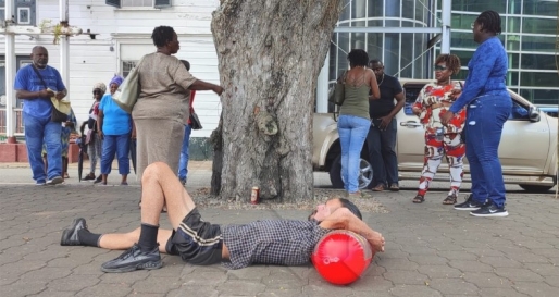 Ronald Fernandes, woordvoerder van de dak- en thuislozen, was er vandaag ook bij om de actie te ondersteunen. Hij lag op de grond als teken van protest. Foto: Suriname Herald Ronald Fernandes, woordvoerder van de dak- en thuislozen, was er vandaag ook bij om de actie te ondersteunen. Hij lag op de grond als teken van protest. Foto: Suriname Herald